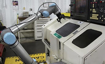 Robotiq 2F-140 gripper mounted on a UR cobot in a machine shop