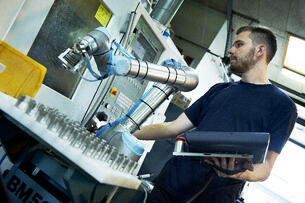Operator setting-up a CNC machine to be automated with a UR cobot