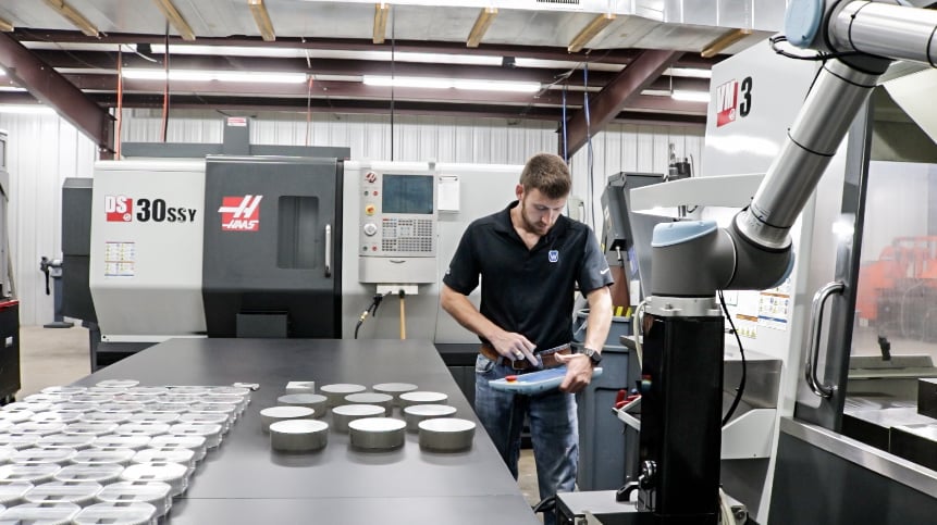 Man programming a Universal Robots for a machine tending application