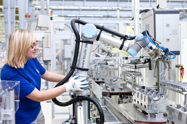 Human working with a cobot in a factory