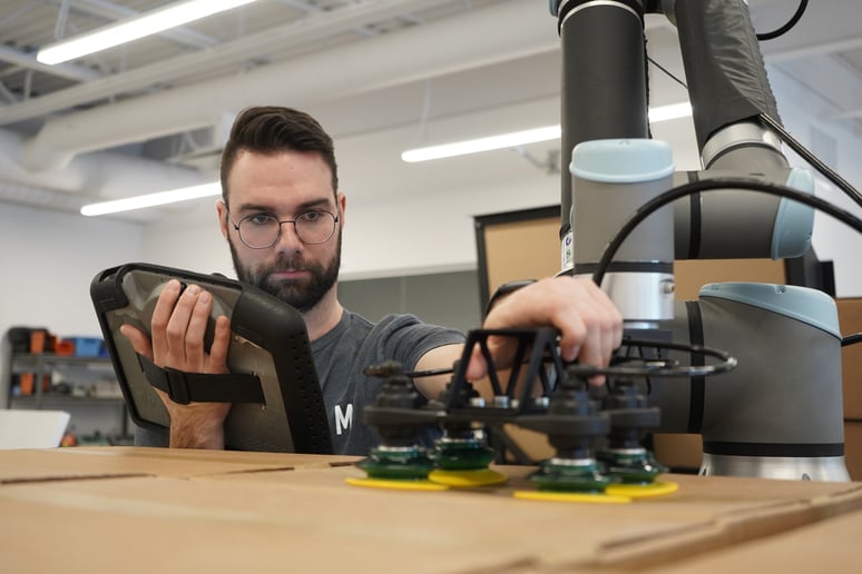 Operator making a robot palletizing program and placing a robotic gripper on cardboxes