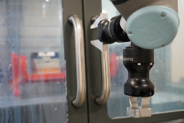 A Robotiq CNC Machine Tending kit opening the door of a CNC machine