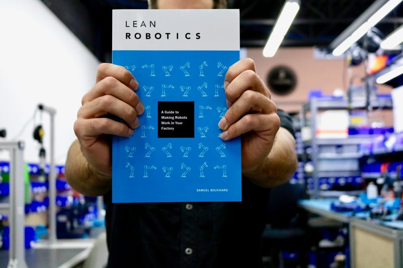 Person holding the Lean Robotics book.