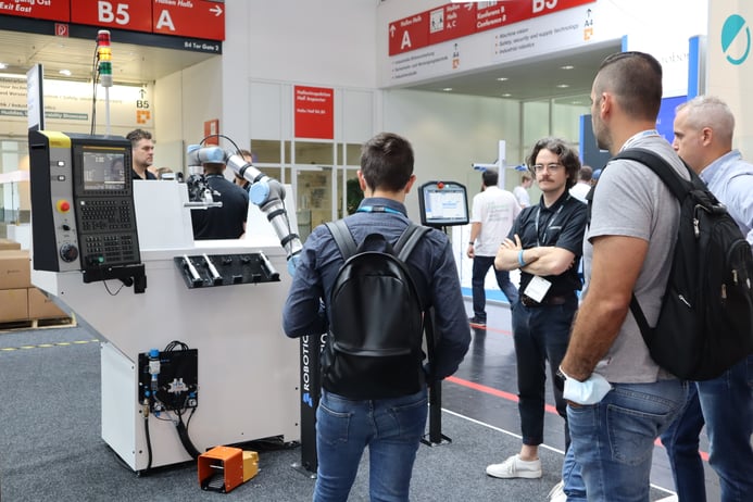 People watching the CNC Machine Tending Demo from Robotiq at Automatica 2022