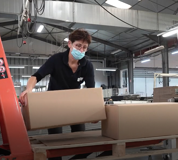 Worker palletizing boxes manually in a manufacture.