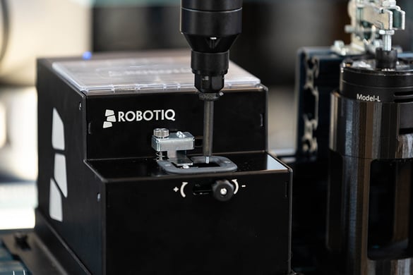 Photo of the Robotiq Screwdriving Solution with its screwdriver taking screw from the screw feeder