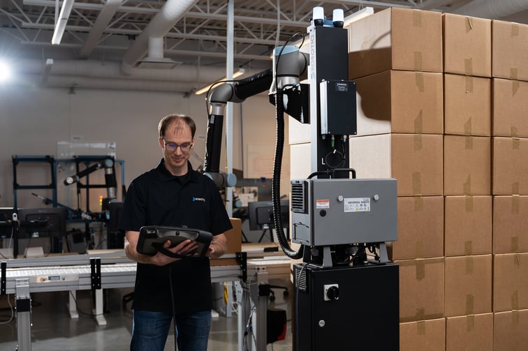 Operator using an automated palletizing system to perform robotic palletizing.