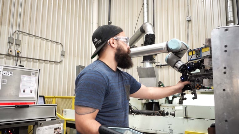 Operator working with a collaborative robot in a cnc shop