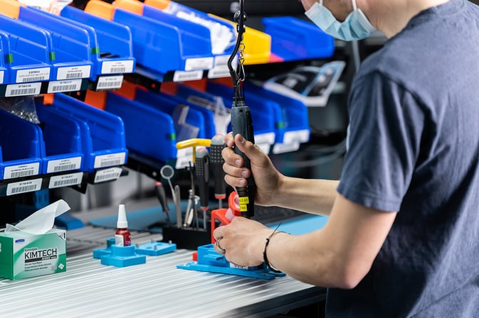 Worker fastening screws with a manual screwdriver