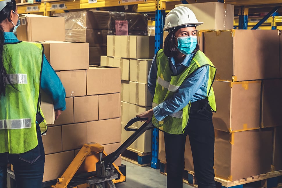 Photo : Woman moving boxes using a pallet jack a 