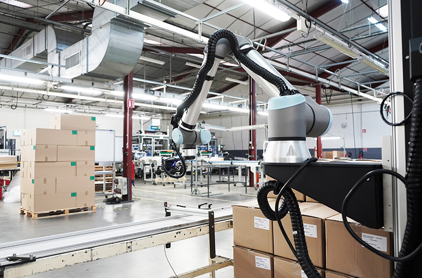 Cobot palletizing cardboard boxes near a conveyor