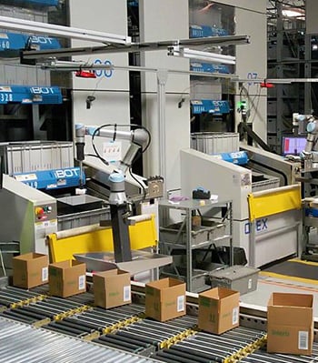 Universal Robots placing parts in boxes with a Robotiq vacuum gripper.