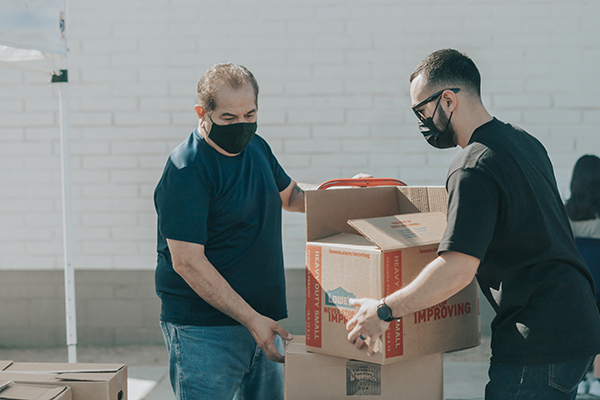 Workers palletizing boxes manually