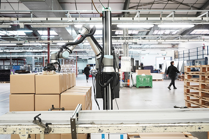 Collaborative robot palletizing cardboard boxes.