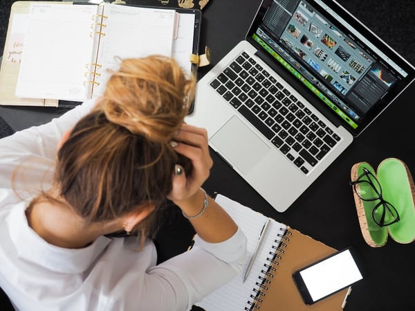 woman-holding-head-in-front-of-computer