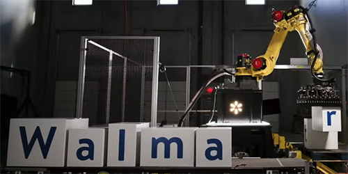 Yellow industrial robot being used to place the walmart letters
