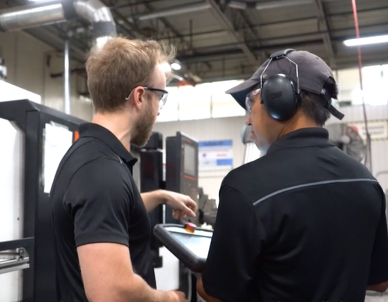 Two workers programming a cobot from universal robot